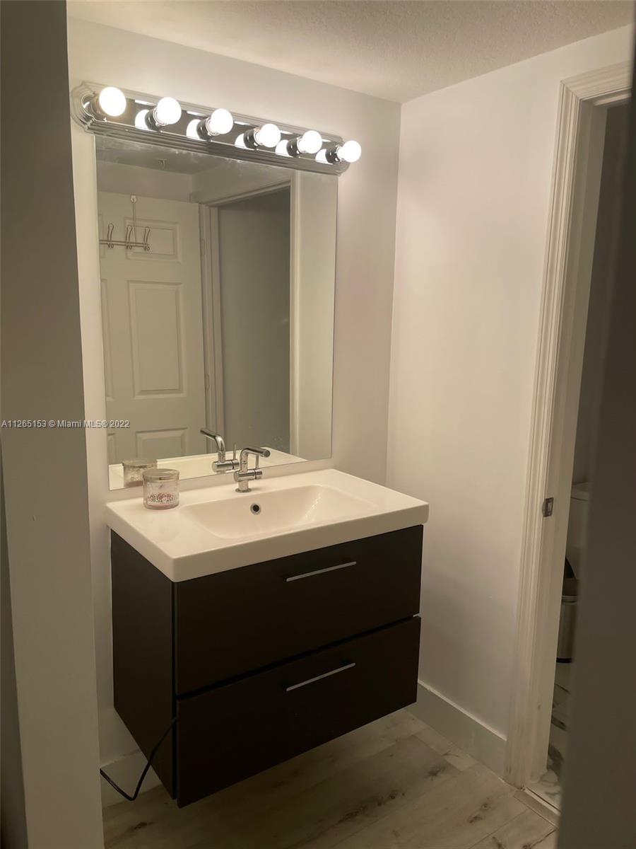 4242 Northwest 2nd Street, Unit 708 Miami, FL 33126 - Photo 12 of 20 a bathroom with a sink and a mirror
