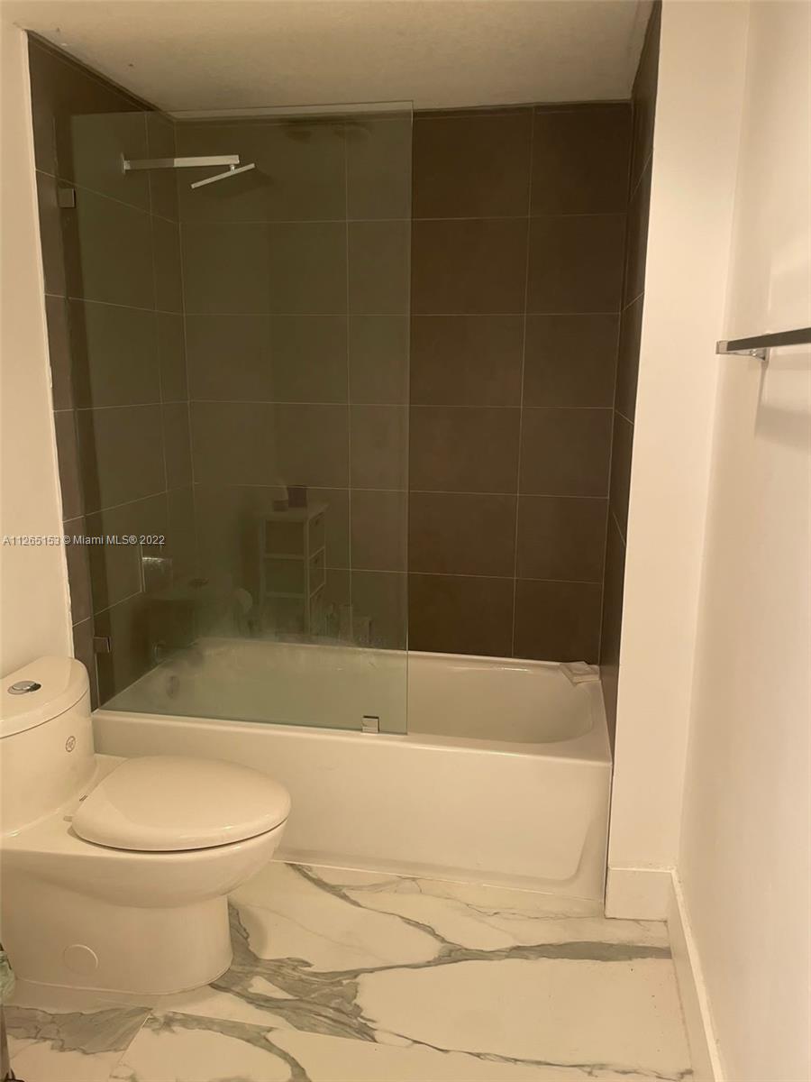 4242 Northwest 2nd Street, Unit 708 Miami, FL 33126 - Photo 13 of 20 a bathroom with a toilet and a shower
