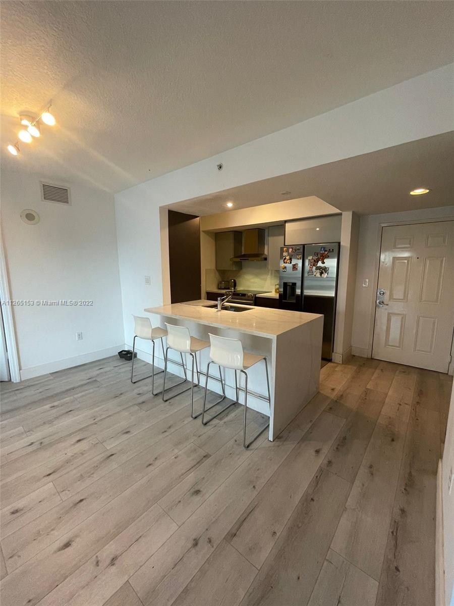 4242 Northwest 2nd Street, Unit 708 Miami, FL 33126 - Photo 6 of 20 a room with furniture and a wooden floor