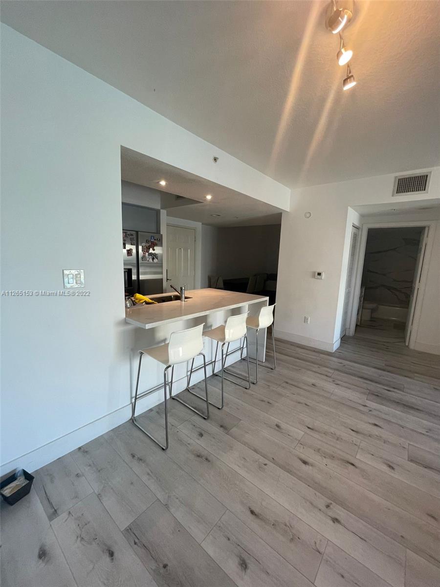 4242 Northwest 2nd Street, Unit 708 Miami, FL 33126 - Photo 7 of 20 a workspace with furniture and wooden floor