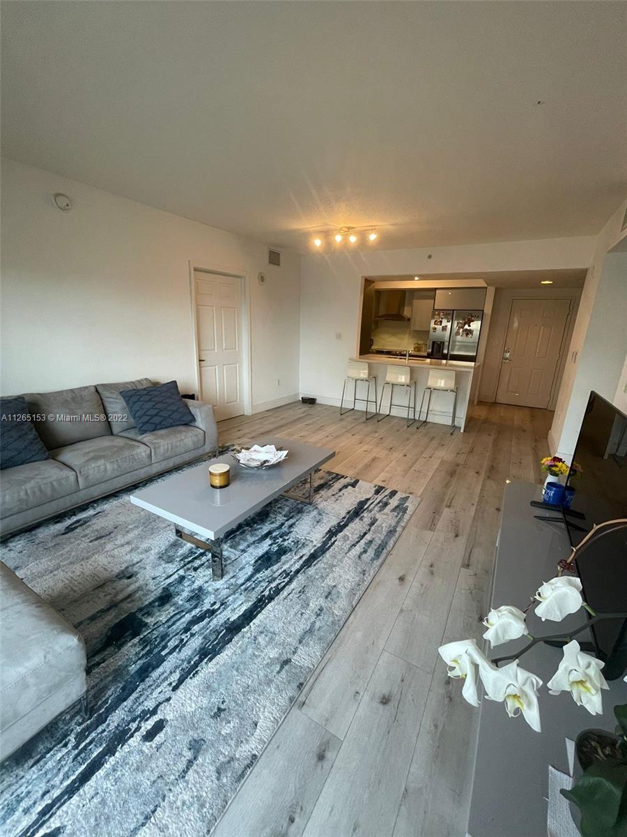 4242 Northwest 2nd Street, Unit 708 Miami, FL 33126 - Photo 8 of 20 a living room with furniture and wooden floor