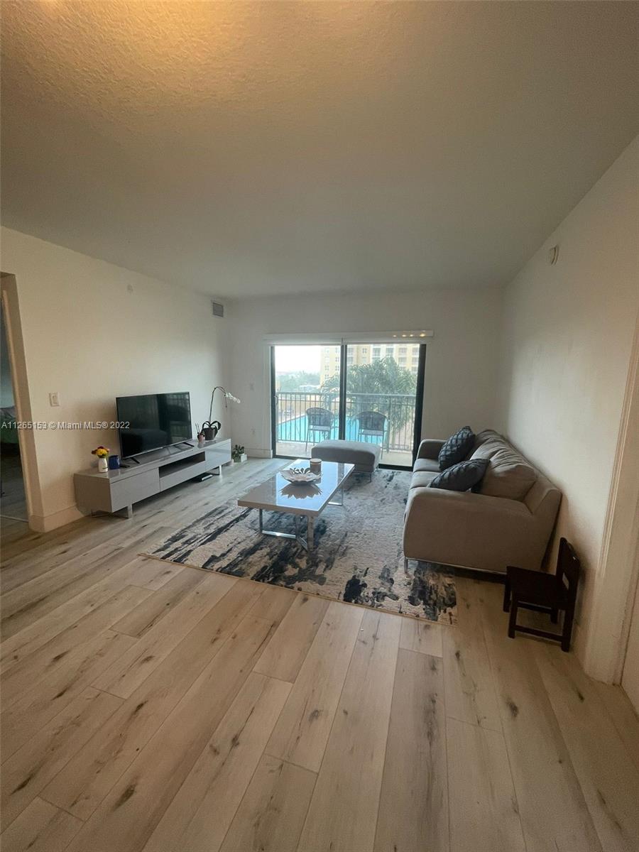 4242 Northwest 2nd Street, Unit 708 Miami, FL 33126 - Photo 9 of 20 a living room with furniture and a flat screen tv