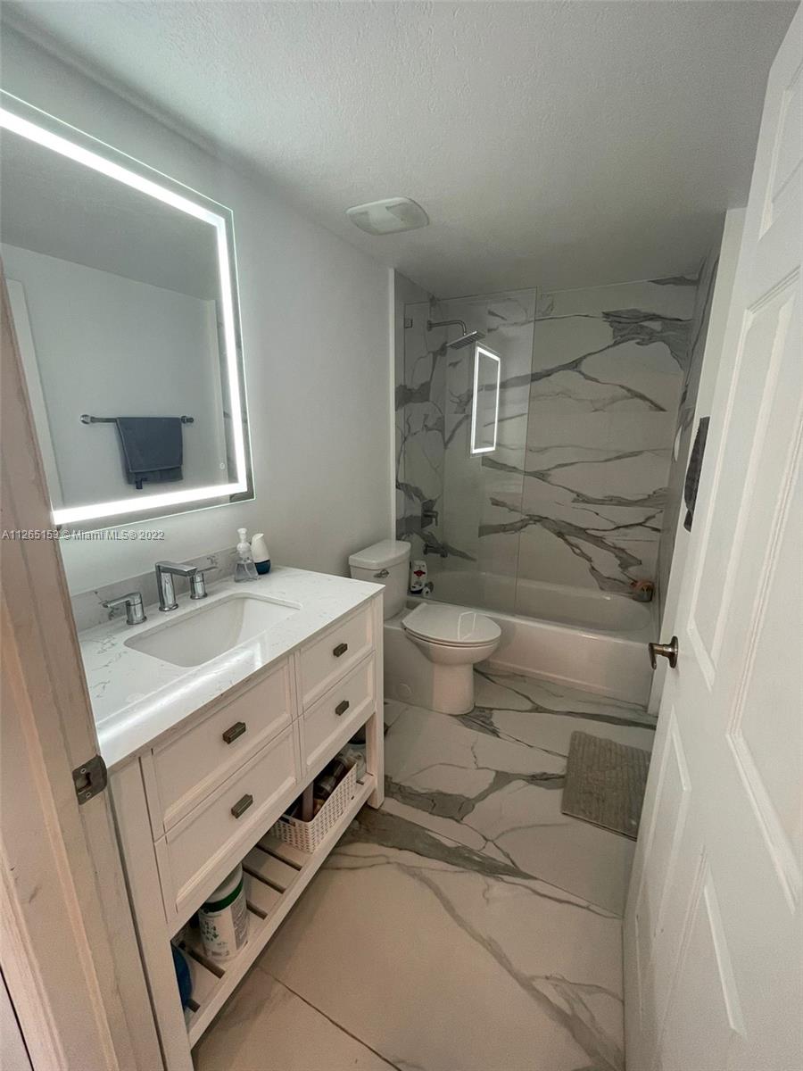4242 Northwest 2nd Street, Unit 708 Miami, FL 33126 - Photo 10 of 20 a bathroom with a double vanity sink mirror and toilet