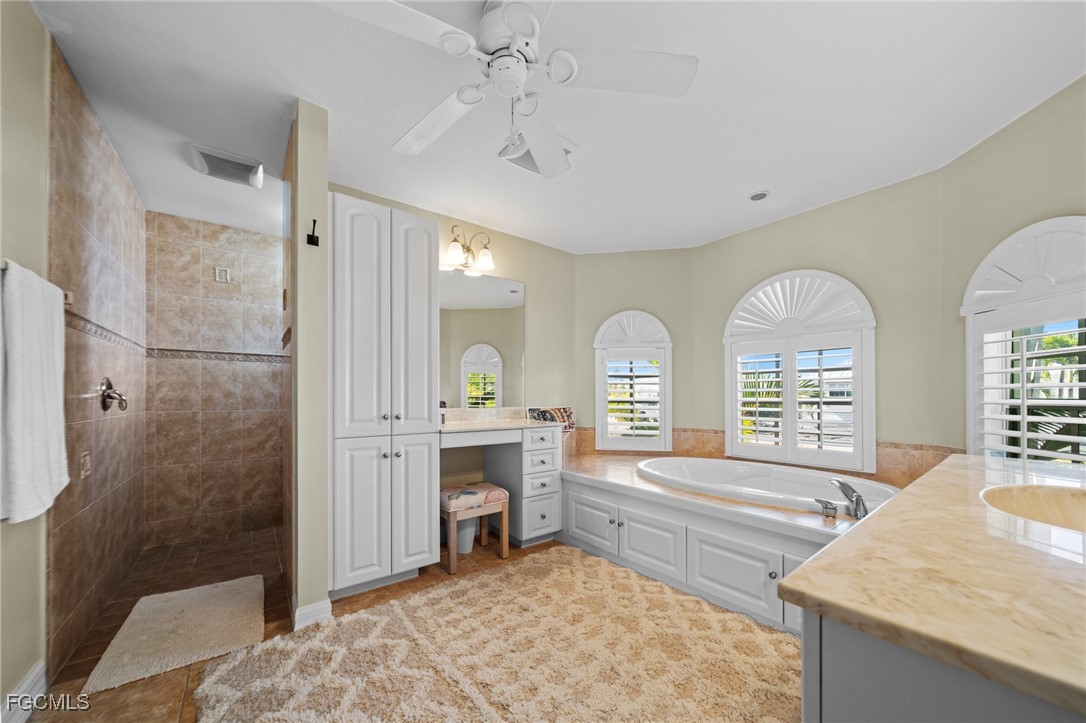 12234 Boat Shell Drive Matlacha Isles, FL 33991 - Photo 19 of 50 a spacious bathroom with a granite countertop sink a mirror and a bathtub