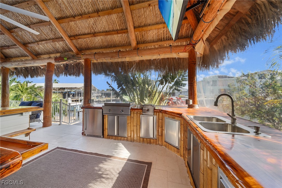 12234 Boat Shell Drive Matlacha Isles, FL 33991 - Photo 32 of 50 a kitchen with stainless steel appliances granite countertop a sink a stove and a wooden cabinets