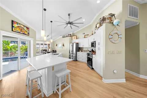 a kitchen with stainless steel appliances sink stove refrigerator and cabinets