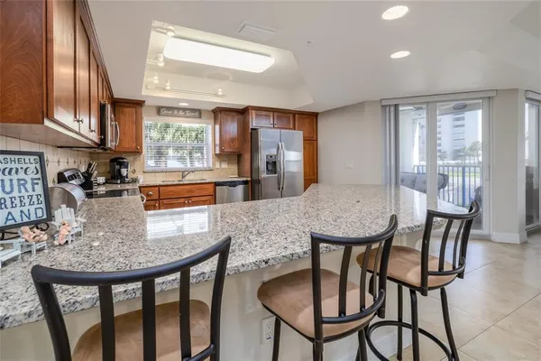 a kitchen with stainless steel appliances granite countertop a dining table chairs and granite counter tops