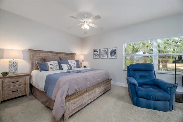 a spacious bedroom with a bed couch and window
