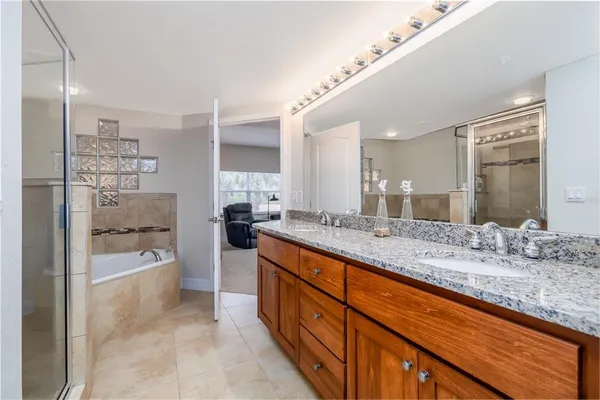 a spacious bathroom with a granite countertop sink mirror and bathtub