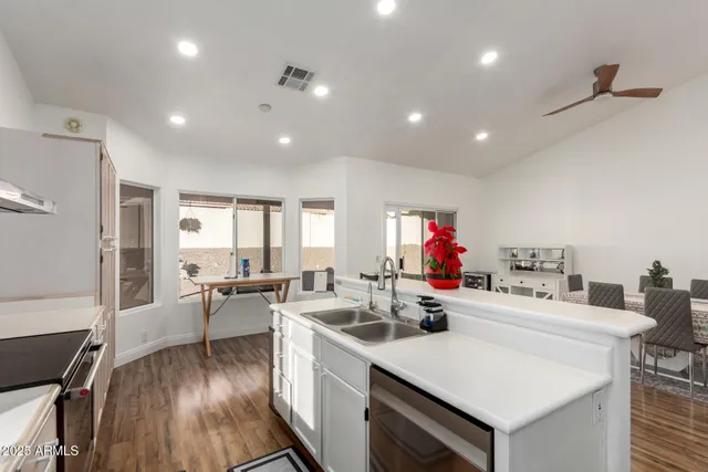 a kitchen that has a lot of cabinets a sink with wooden floor and furniture