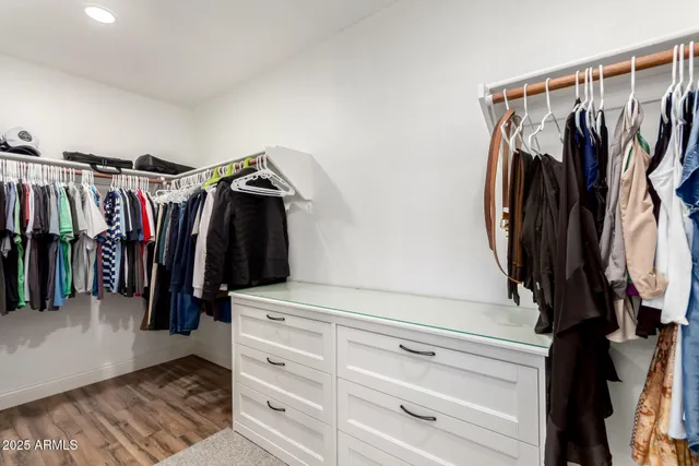 a view of walk in closet with clothes and shoes