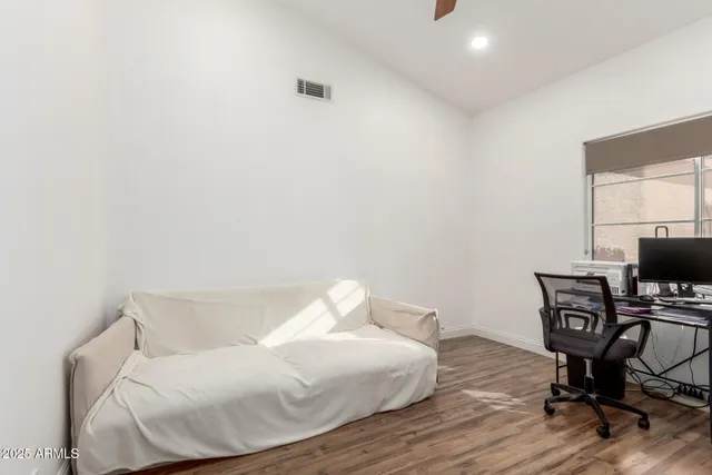 a view of a workspace with furniture and wooden floor
