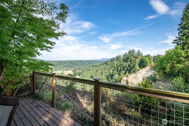 a view of a balcony with wooden floor & fence
