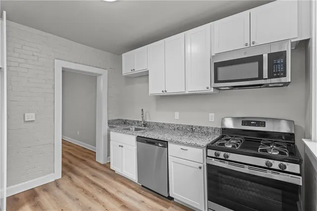 a kitchen with stainless steel appliances a stove a microwave and cabinets
