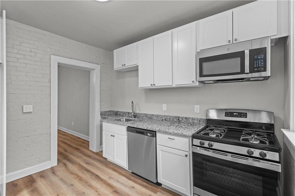 1238 Church Avenue McKees Rocks, PA 15136 - Photo 14 of 25 a kitchen with stainless steel appliances a stove a microwave and cabinets