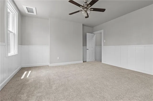 an empty room with a window and a fan