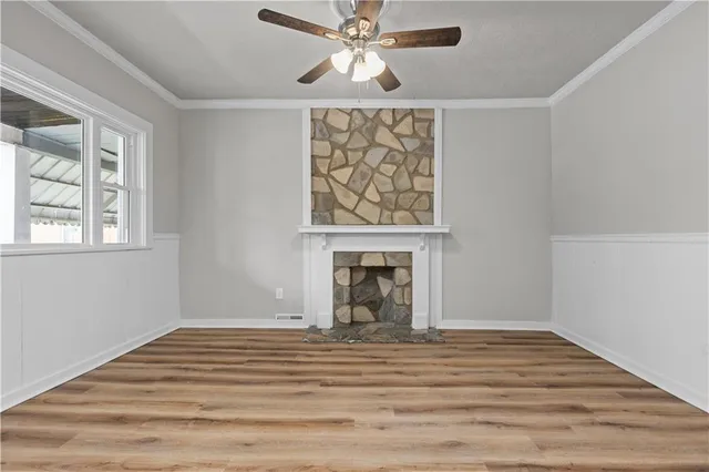 a view of a livingroom with a fireplace and chandelier fan
