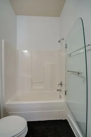 a bathroom with a granite countertop sink a toilet and a mirror