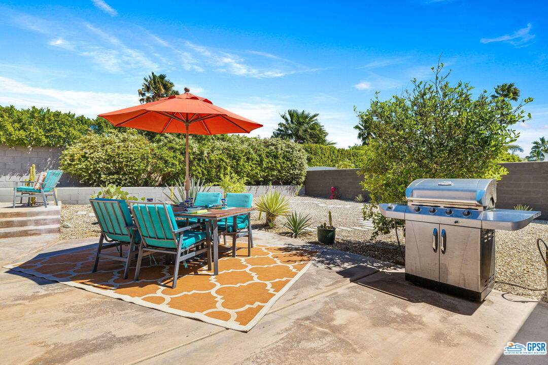 1250 East Delgado Road Palm Springs, CA 92262 - Photo 21 of 35 a view of a backyard with table and chairs under an umbrella