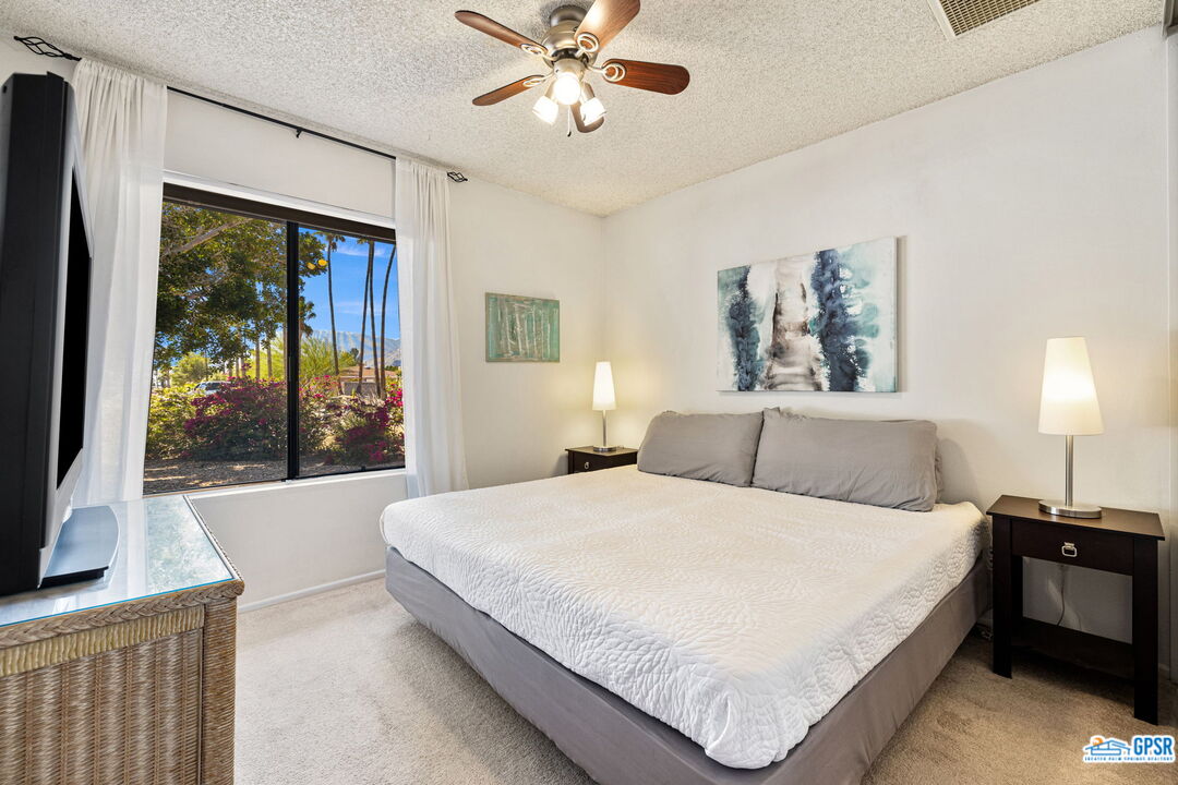 1250 East Delgado Road Palm Springs, CA 92262 - Photo 28 of 35 a bedroom with a large bed and a chandelier
