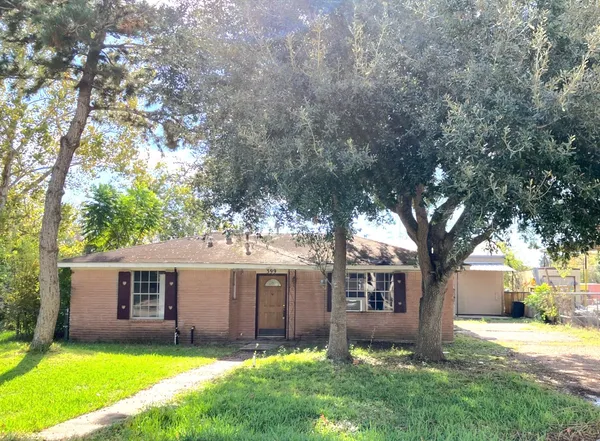 a front view of a house with a yard and trees
