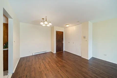 a view of a room with wooden floor and a chandelier