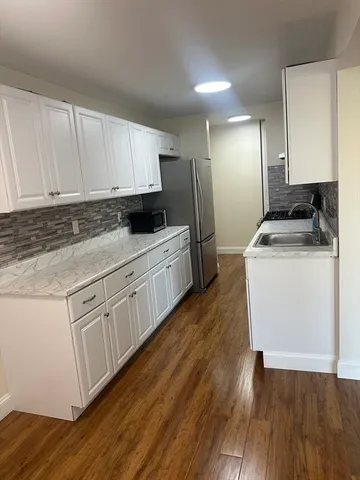 a kitchen with granite countertop a sink stove and cabinets