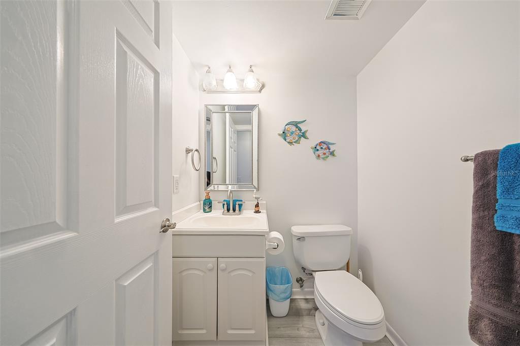 19930 Gulf Boulevard, Unit 1B Indian Shores, FL 33785 - Photo 11 of 26 a white toilet sitting next to a bathroom sink