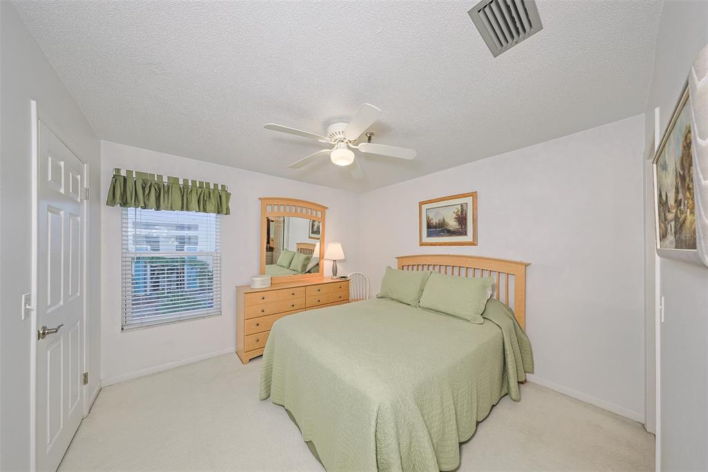 19930 Gulf Boulevard, Unit 1B Indian Shores, FL 33785 - Photo 12 of 26 a bedroom with a bed and a chandelier