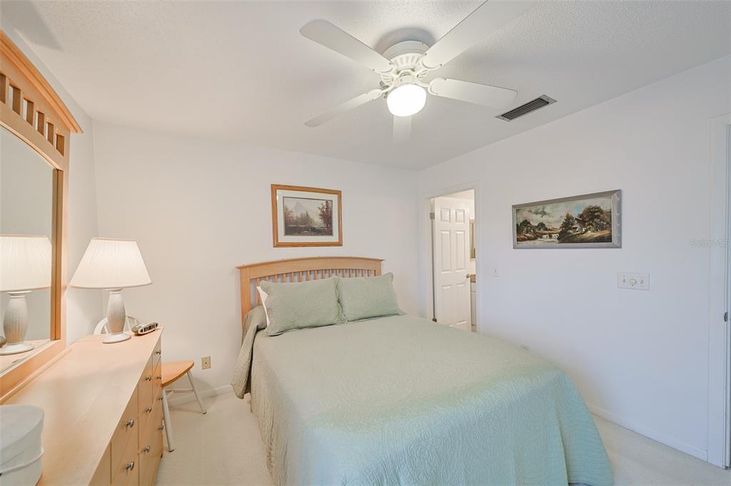 19930 Gulf Boulevard, Unit 1B Indian Shores, FL 33785 - Photo 14 of 26 a bedroom with a bed and a chandelier
