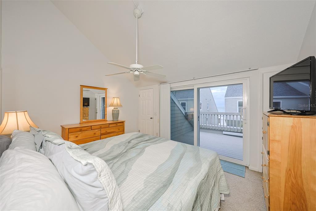 19930 Gulf Boulevard, Unit 1B Indian Shores, FL 33785 - Photo 16 of 26 a bedroom with a large bed and a chandelier