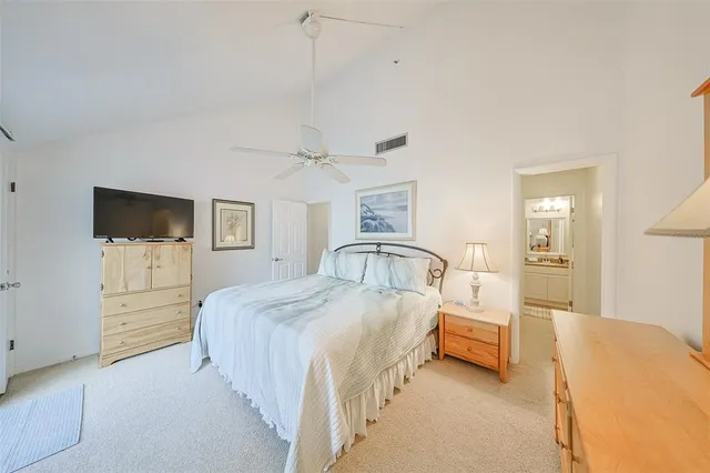 a spacious bedroom with a bed and a flat screen tv