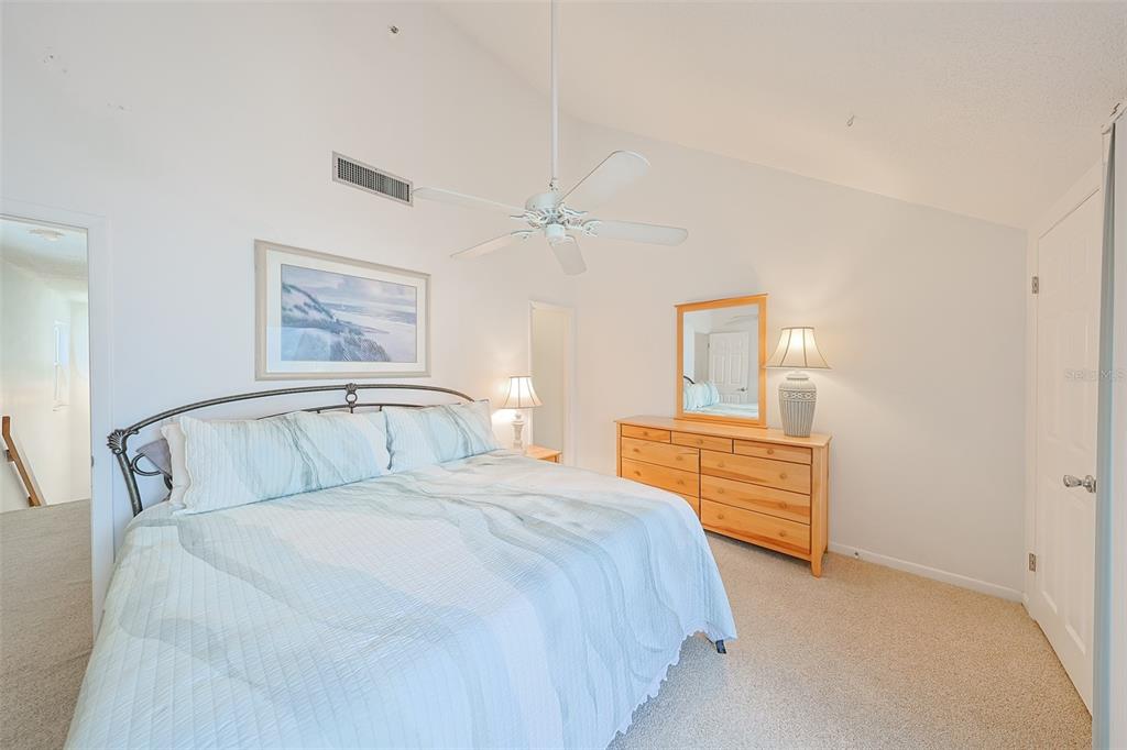 19930 Gulf Boulevard, Unit 1B Indian Shores, FL 33785 - Photo 19 of 26 a bedroom with a bed and a chandelier