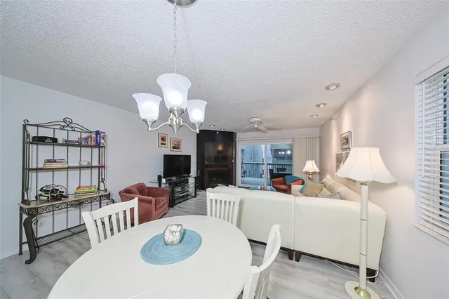 a living room with furniture a chandelier and a dining room