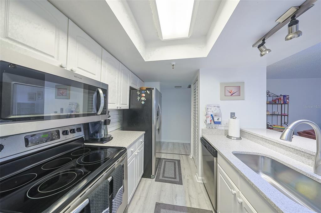 19930 Gulf Boulevard, Unit 1B Indian Shores, FL 33785 - Photo 9 of 26 a kitchen with stainless steel appliances and white cabinets
