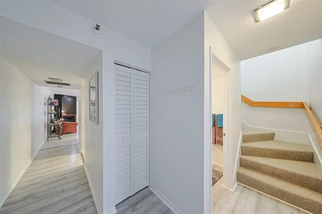 a view of a hallway with wooden floor and entryway