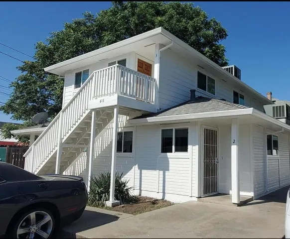 a front view of a house with a parking space