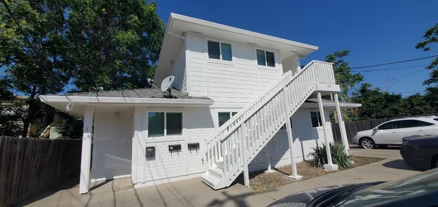 a view of a house with wooden deck and furniture