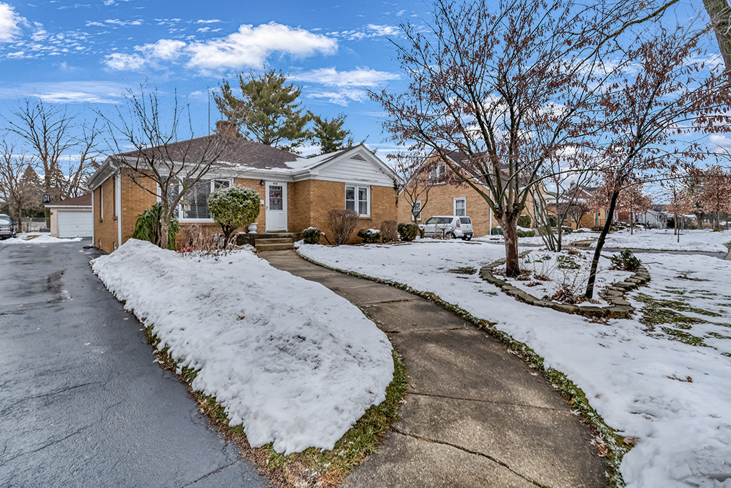 a view of a house with a yard covered with snow in front of house