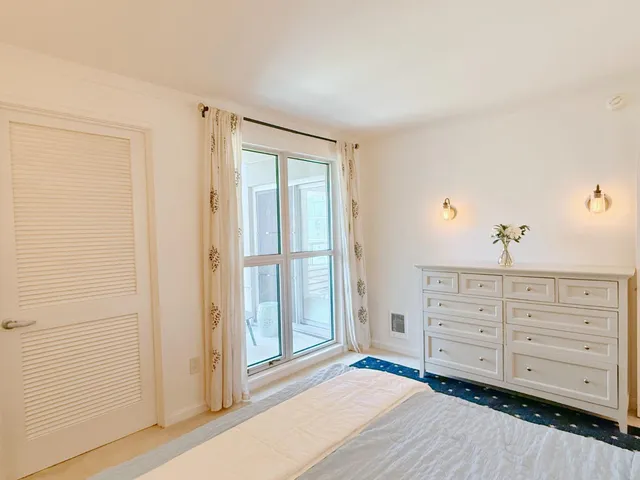 a view of a bedroom with cabinet and window