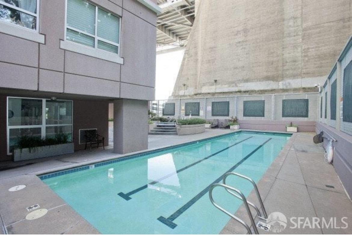 400 Beale Street, Unit 1102 San Francisco, CA 94105 - Photo 26 of 26 a view of a patio with couches table and chairs under an umbrella with large windows