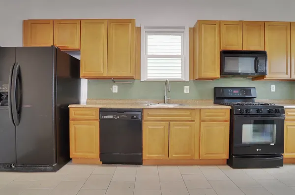 a kitchen with stainless steel appliances granite countertop a stove a refrigerator and a sink