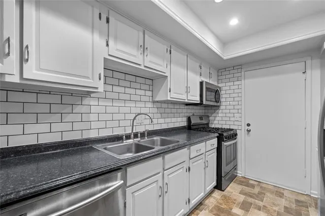 a kitchen with stainless steel appliances granite countertop a sink stove and cabinets