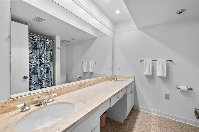 a spacious bathroom with a granite countertop sink and a bathtub