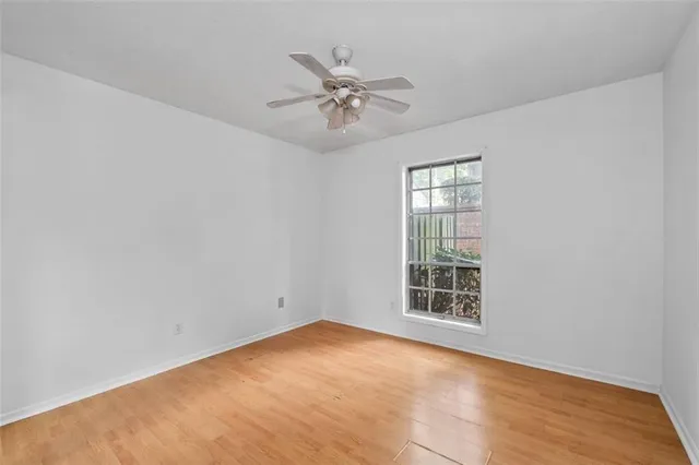 an empty room with a ceiling fan and window