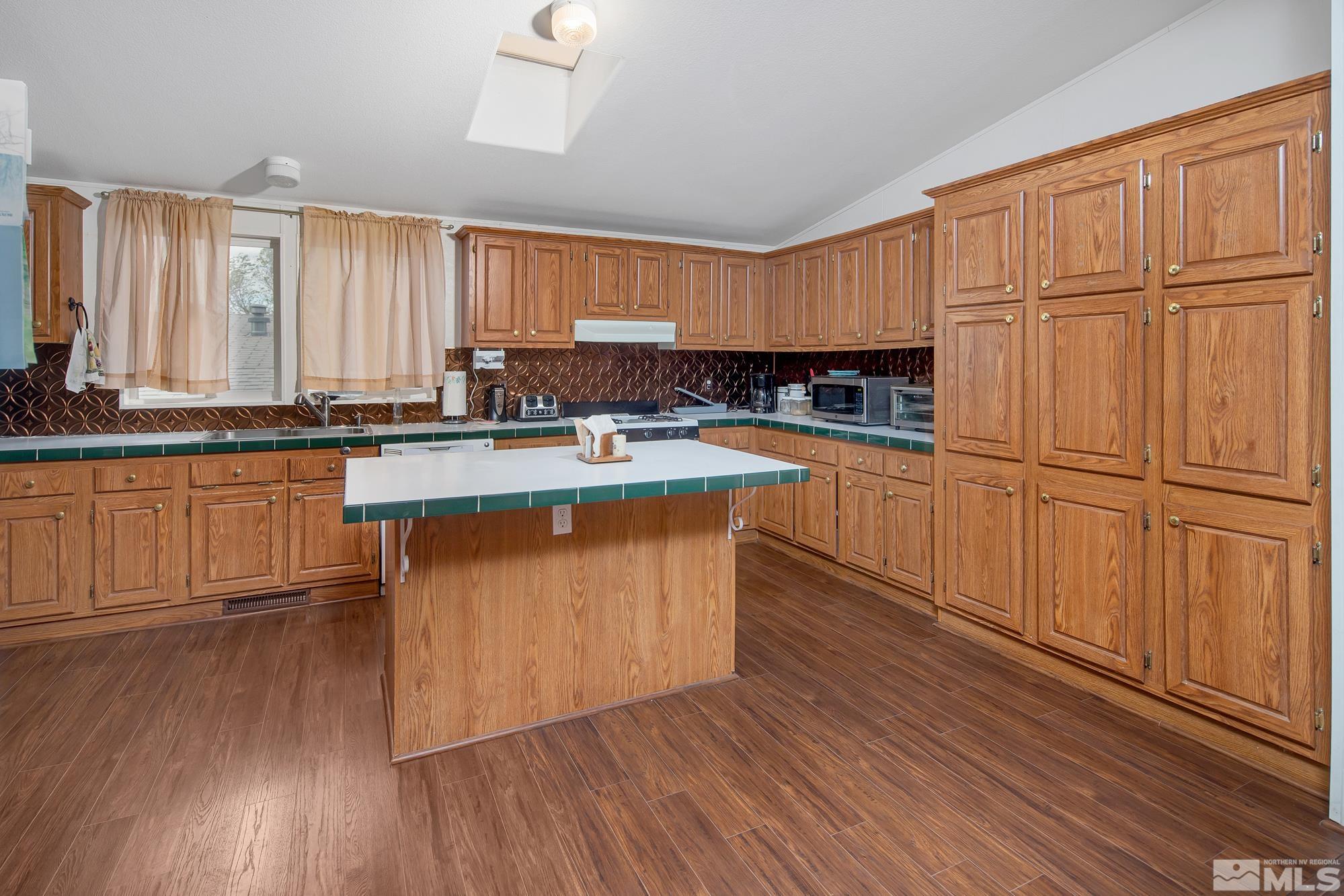 4963 Newport Court Reno, NV 89506 - Photo 3 of 19 a kitchen with wooden floors and wooden cabinets
