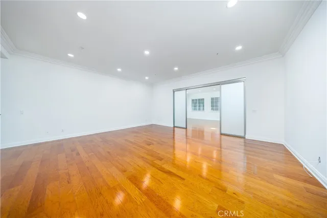 a view of empty room with wooden floor