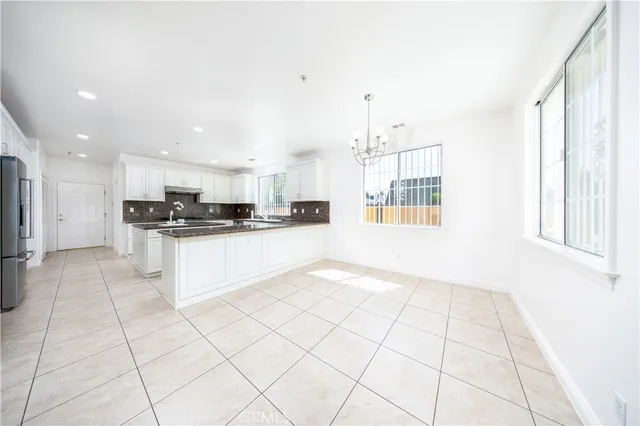 a kitchen with stainless steel appliances kitchen island granite countertop a refrigerator a sink and a stove