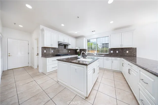 a large kitchen with stainless steel appliances granite countertop a sink and cabinets
