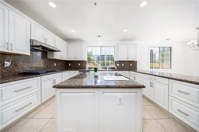 a kitchen with granite countertop a sink white cabinets and a granite counter tops